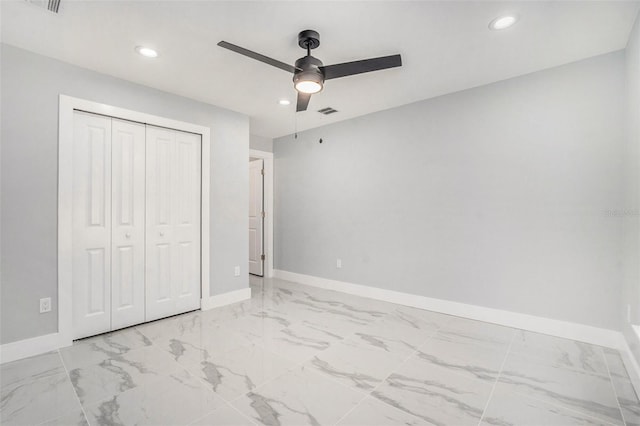 unfurnished bedroom with a closet, visible vents, marble finish floor, and baseboards