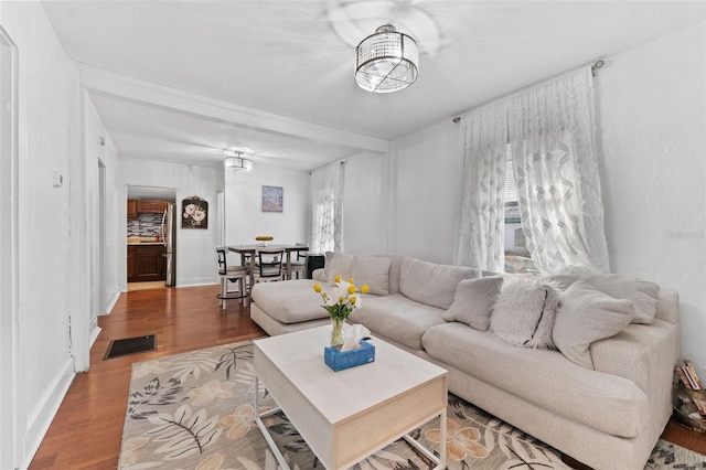 living room featuring wood finished floors, visible vents, and baseboards