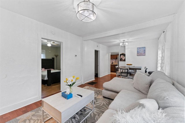 living area featuring a chandelier, visible vents, baseboards, and wood finished floors