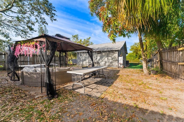 view of yard with a gazebo, an outdoor living space, a patio, and a fenced backyard