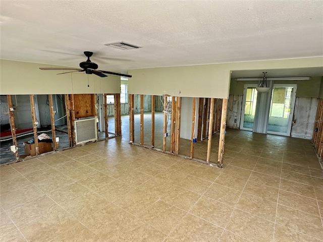 unfurnished room with visible vents, a textured ceiling, a healthy amount of sunlight, and a ceiling fan