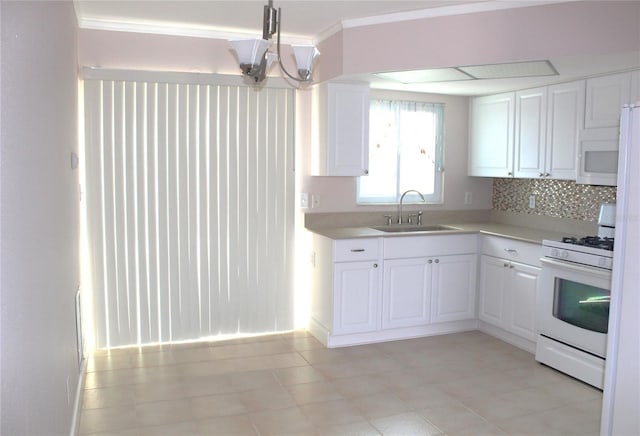 kitchen featuring white appliances, white cabinetry, light countertops, and a sink