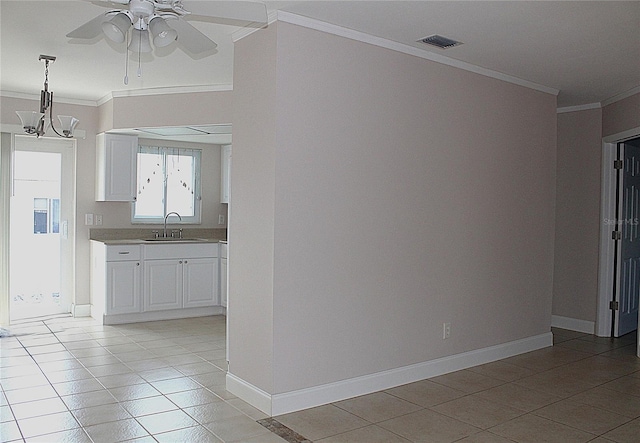 interior space featuring a sink, visible vents, baseboards, and crown molding