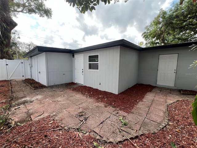 back of house with a patio area, fence, and a gate