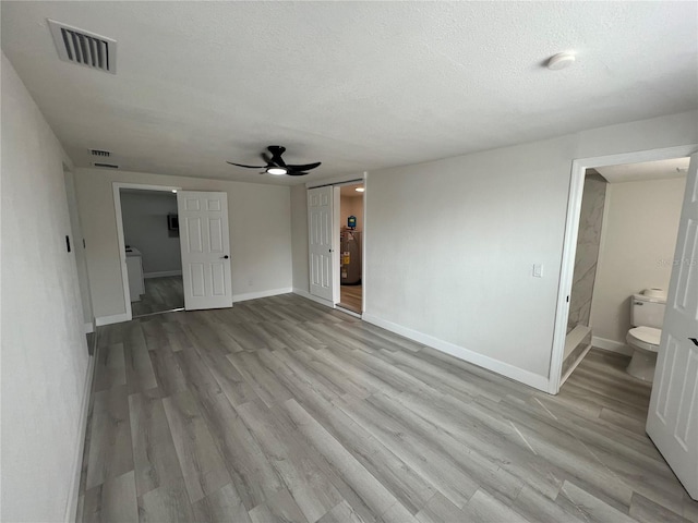 interior space featuring connected bathroom, visible vents, baseboards, and light wood-style flooring