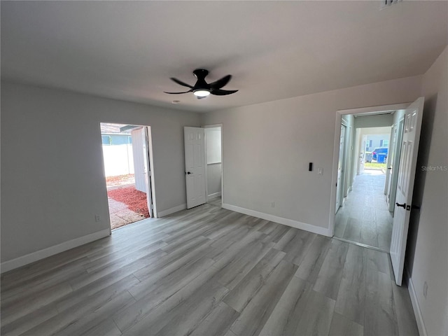 spare room with baseboards, plenty of natural light, and light wood finished floors