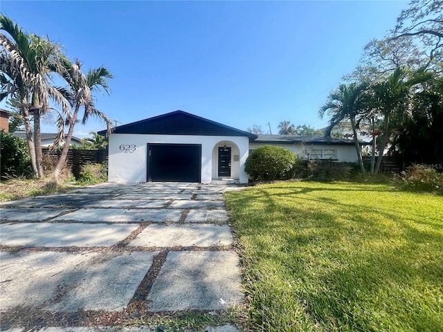 exterior space featuring a garage, stucco siding, concrete driveway, and a front yard