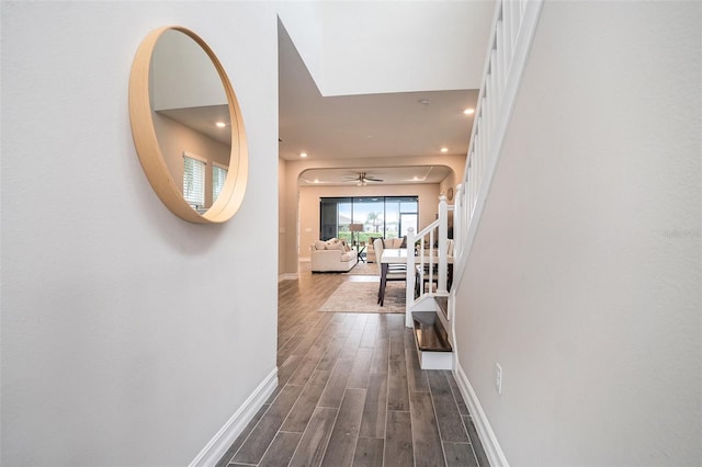 corridor featuring stairway, recessed lighting, dark wood-type flooring, and baseboards