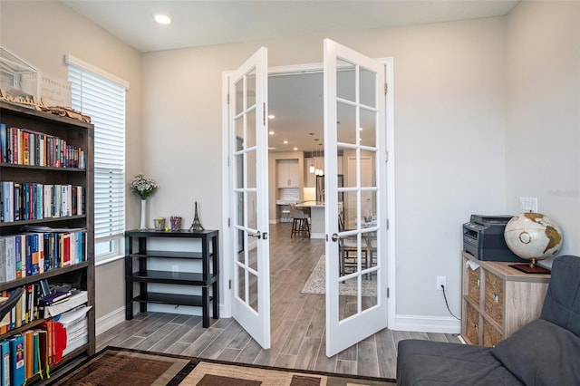 living area featuring french doors, baseboards, and wood finish floors