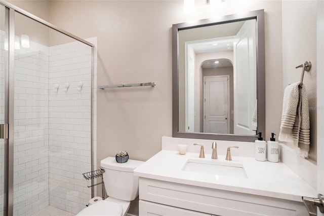 full bathroom with vanity, toilet, and a shower stall