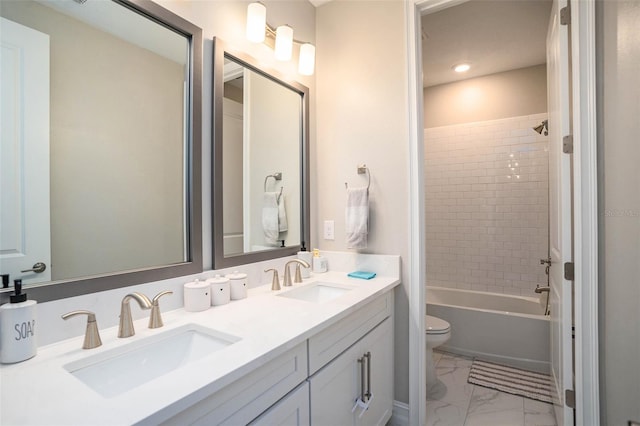 bathroom with double vanity, marble finish floor, toilet, and a sink