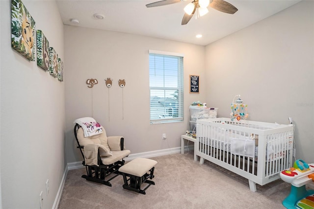 carpeted bedroom featuring recessed lighting, ceiling fan, a crib, and baseboards