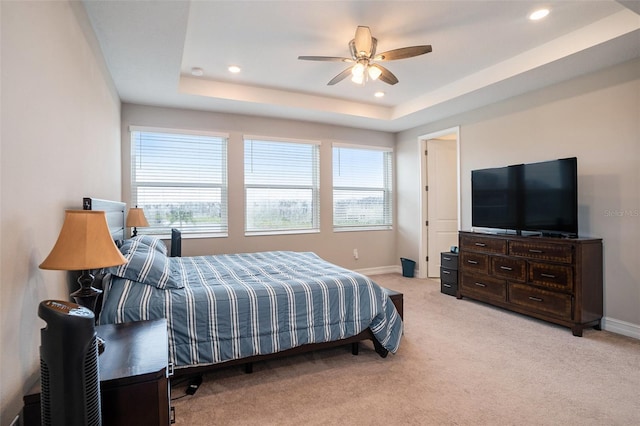 bedroom with a ceiling fan, baseboards, a tray ceiling, recessed lighting, and light colored carpet