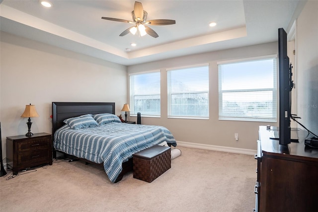 bedroom with light carpet, recessed lighting, baseboards, and a tray ceiling