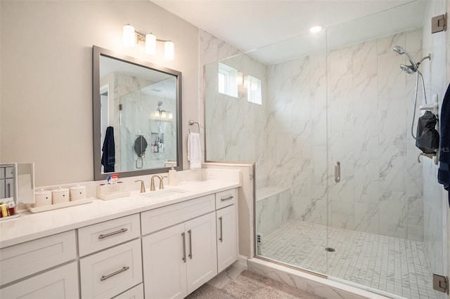 bathroom featuring a marble finish shower and vanity