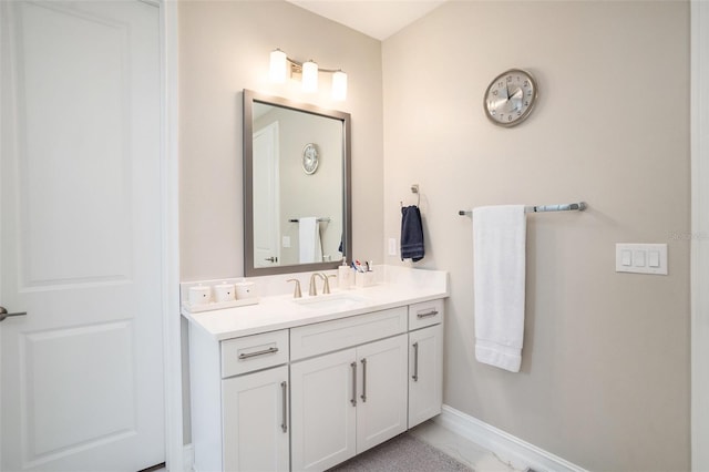 bathroom featuring baseboards, marble finish floor, and vanity