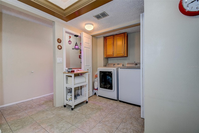 5920 80th St N Unit 107, Saint Petersburg, FL 33709 - washroom with visible vents, light tile patterned floors, washer and dryer, cabinet space, and a textured ceiling