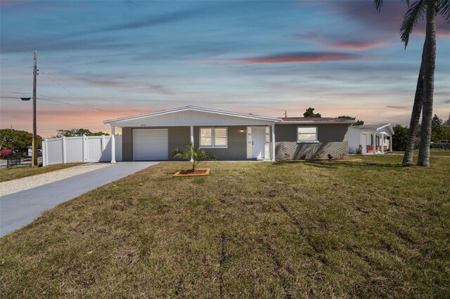 view of front of home featuring a garage, a front lawn, driveway, and fence