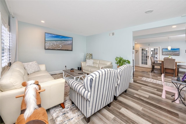 living room featuring light wood-style flooring, recessed lighting, visible vents, and baseboards