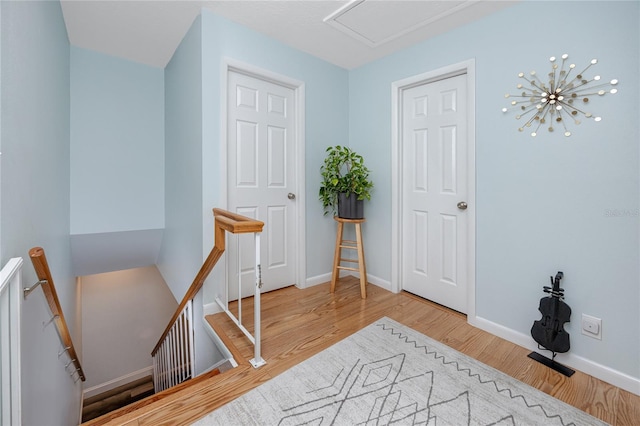 interior space with wood finished floors, an upstairs landing, and baseboards