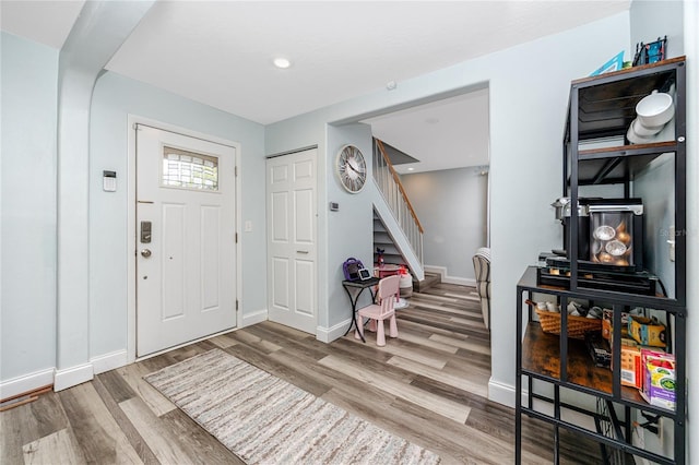 entryway featuring stairs, baseboards, and wood finished floors