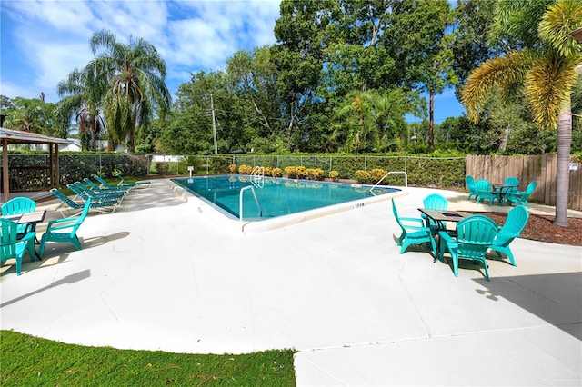 pool with a patio and fence