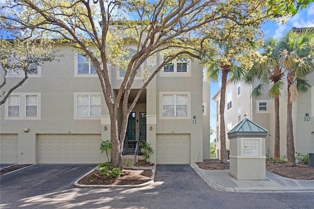 view of front of home featuring stucco siding, driveway, and a garage