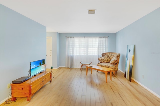 sitting room with baseboards, visible vents, and light wood-type flooring