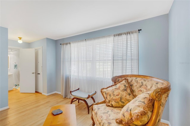 sitting room featuring a wealth of natural light, baseboards, and wood finished floors