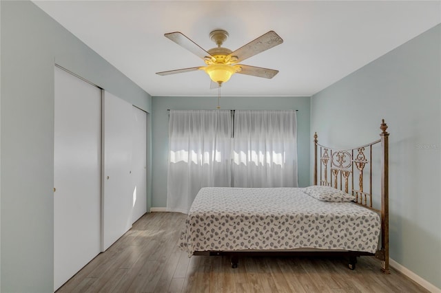 bedroom with ceiling fan, baseboards, and wood finished floors