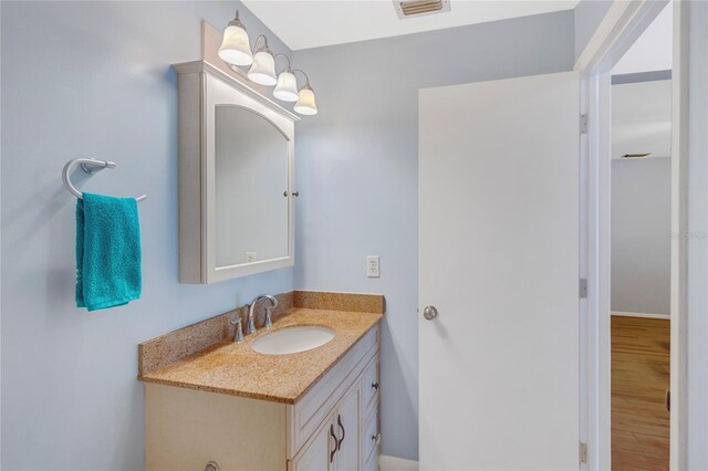 bathroom with visible vents, wood finished floors, and vanity