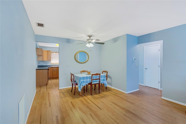 dining room with baseboards, visible vents, and light wood finished floors