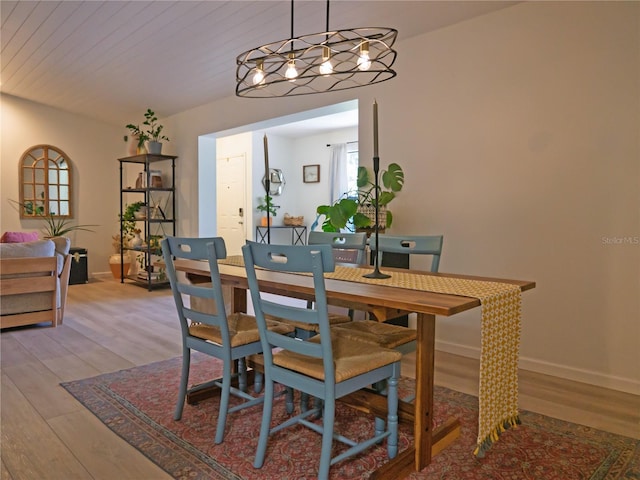 dining space with wooden ceiling, baseboards, and light wood-type flooring