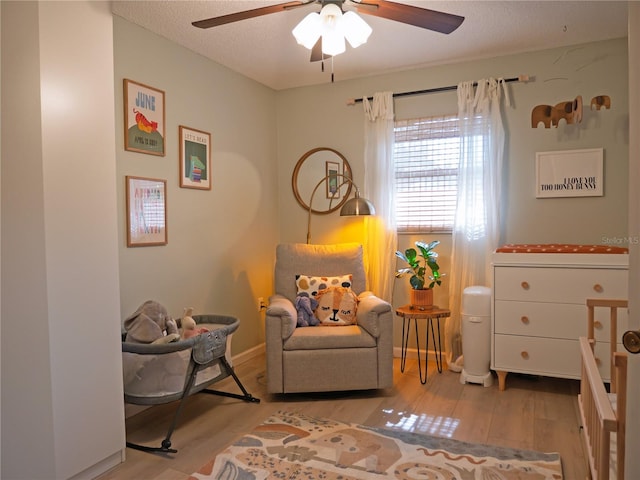 sitting room featuring ceiling fan, a textured ceiling, and wood finished floors