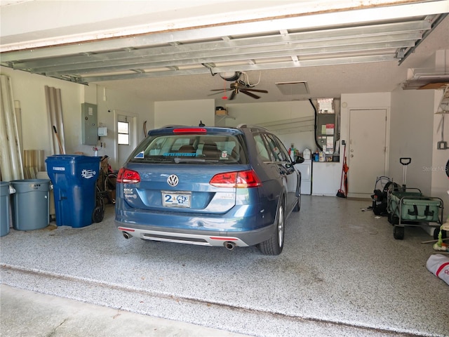 garage featuring electric panel, heating unit, and a garage door opener