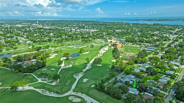 drone / aerial view featuring golf course view and a water view