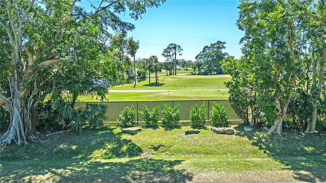 view of home's community with a yard and fence