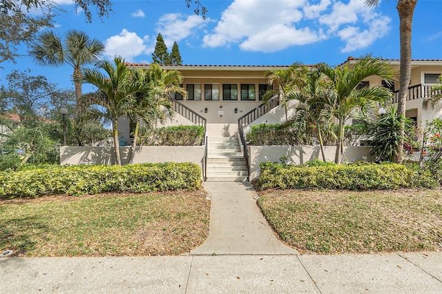 view of front of house with stairs and stucco siding