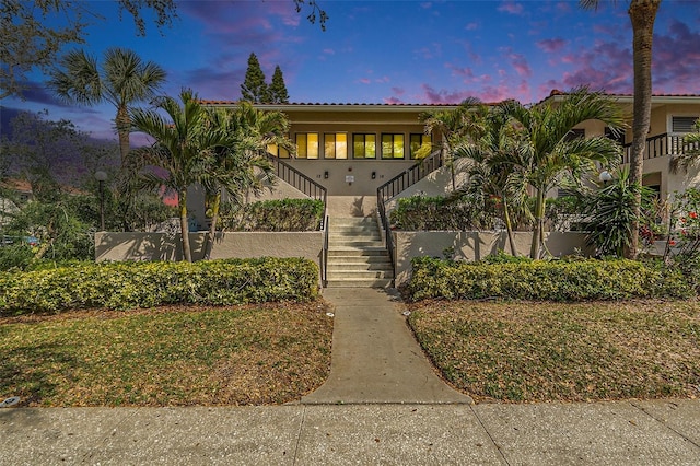 view of front of home with stucco siding and stairs