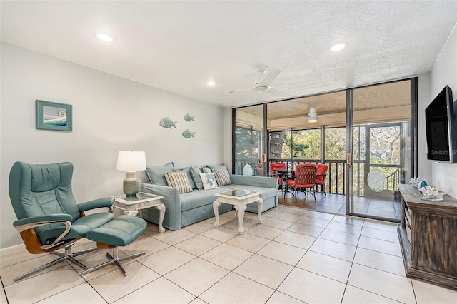 living area with a ceiling fan, a textured ceiling, floor to ceiling windows, recessed lighting, and light tile patterned floors