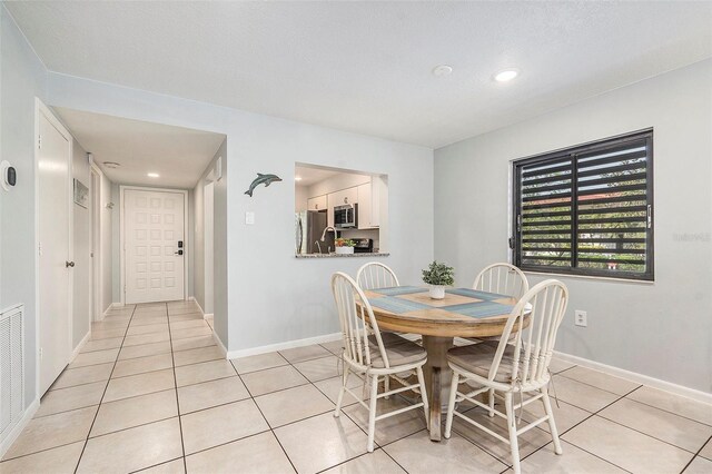 dining space with light tile patterned floors, recessed lighting, and baseboards