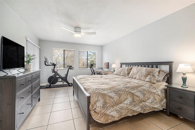 bedroom with ceiling fan, light tile patterned floors, and a textured ceiling