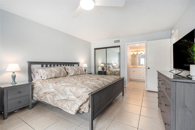 bedroom with ensuite bath, light tile patterned floors, a ceiling fan, and visible vents