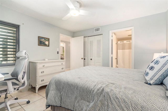 bedroom with visible vents, light tile patterned floors, a ceiling fan, and a closet