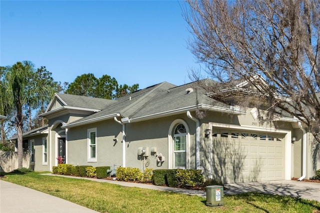 ranch-style home featuring a front lawn, roof with shingles, stucco siding, a garage, and driveway