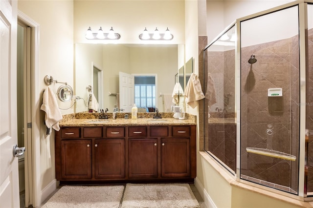 full bathroom with a sink, double vanity, and tiled shower