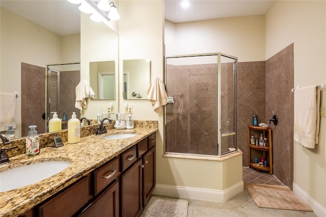 bathroom featuring a sink, baseboards, a stall shower, and double vanity