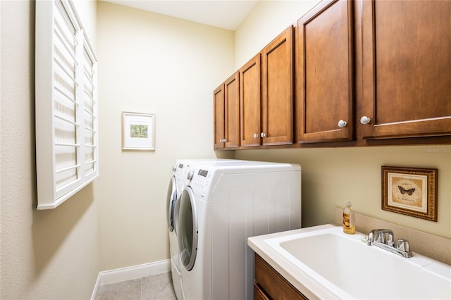 clothes washing area with baseboards, cabinet space, a sink, tile patterned flooring, and independent washer and dryer