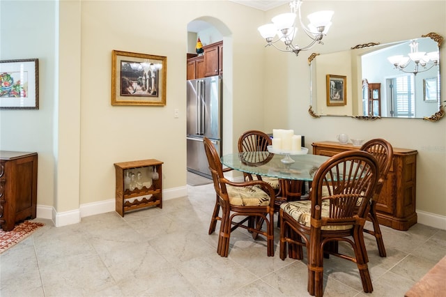 dining space with light tile patterned floors, baseboards, arched walkways, and a chandelier