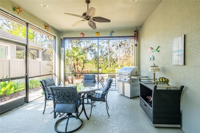 sunroom / solarium featuring a ceiling fan